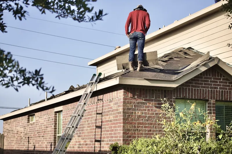 Professional roofer working on a residential roof in Mianus
